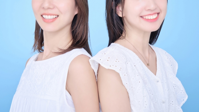 2人の笑顔の女性が背中合わせ